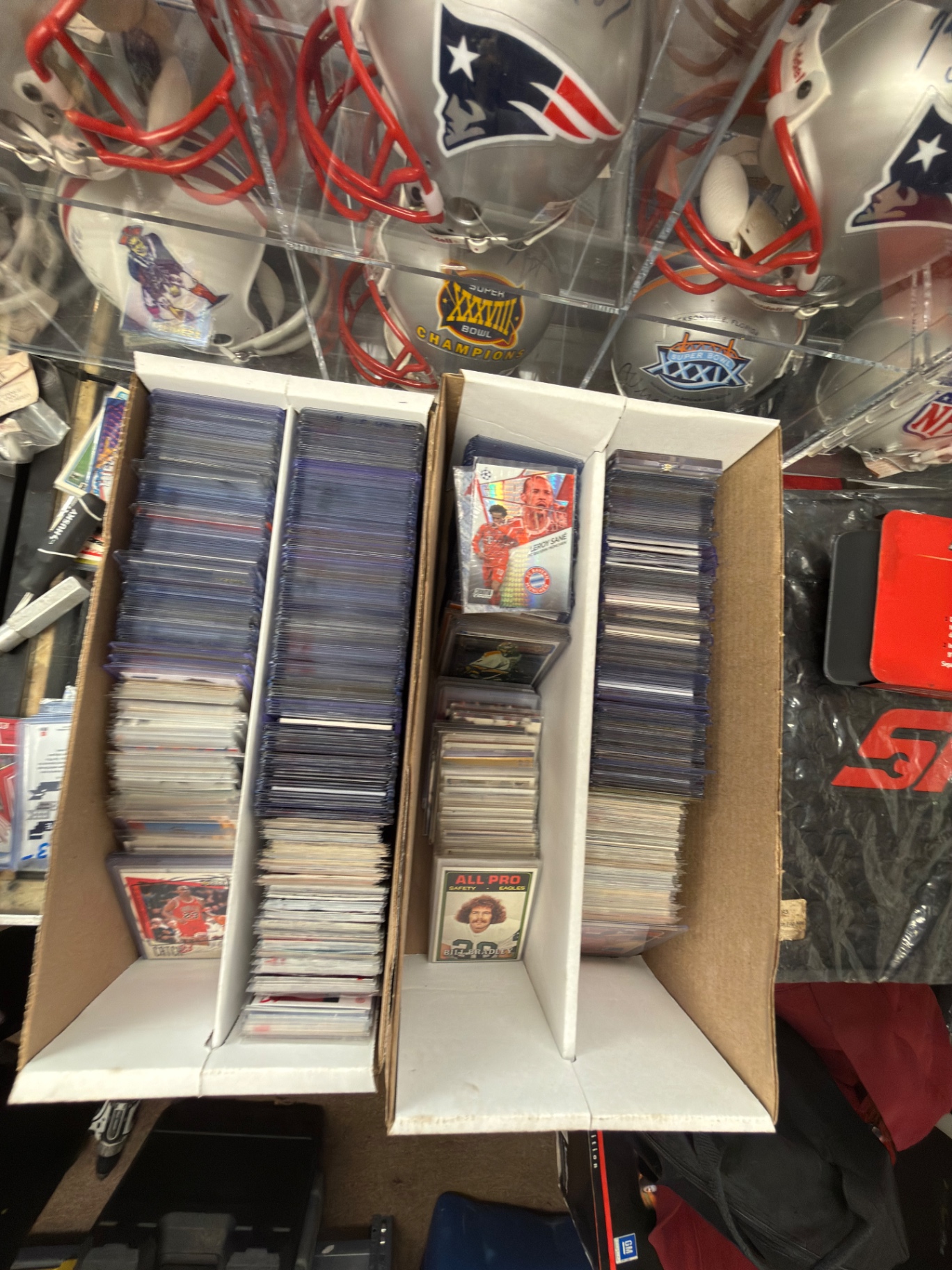 Boxes of sports trading cards under Patriots helmet display
