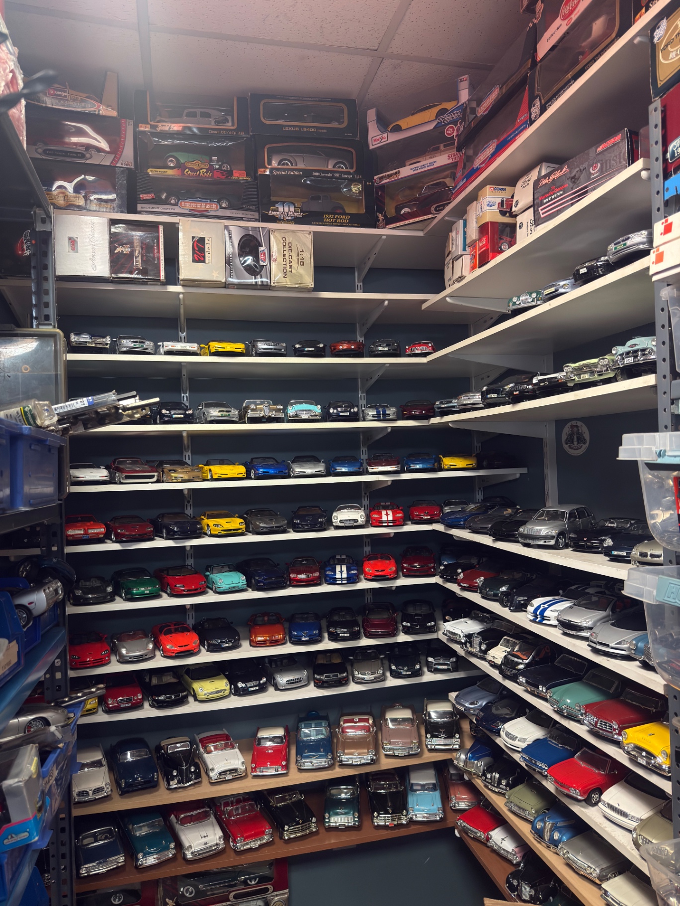 Wall of 1:18 scale diecast model cars on shelves
